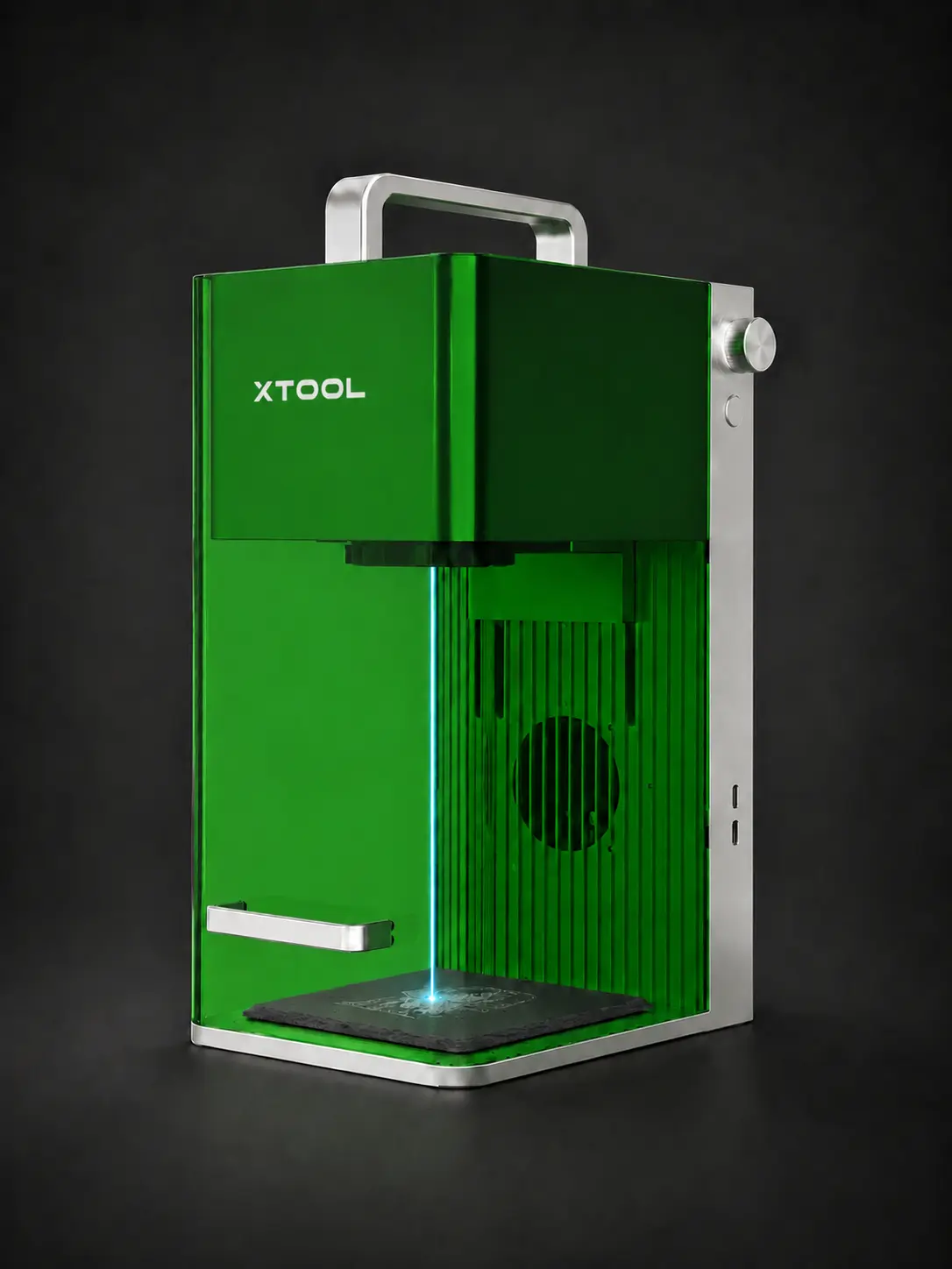 A branded green xTool laser engraving machine working on a slate memorial